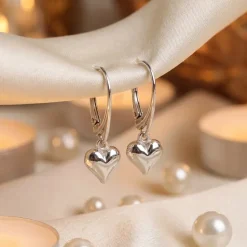 Sterling silver lever back puffed heart earrings hanging on silk