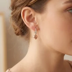 Model wears Rose Gold puffed hear earrings on sterling silver leverbacks
