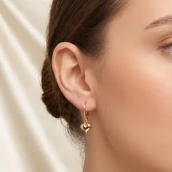 model wears gold hearts desire earrings