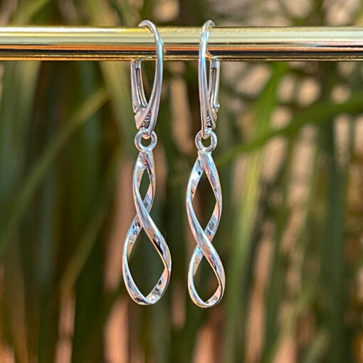 Silver Spiral Lever Back Earrings on a natural background hanging From a gold bar.
