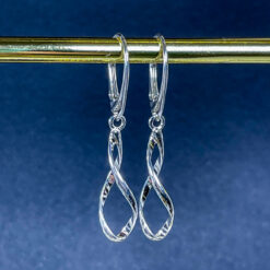 Spiral Silver Leverback Earrings hanging on a gold bar with a blue background.