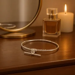 Sterling silver T bar charm bracelet displayed on dressing table